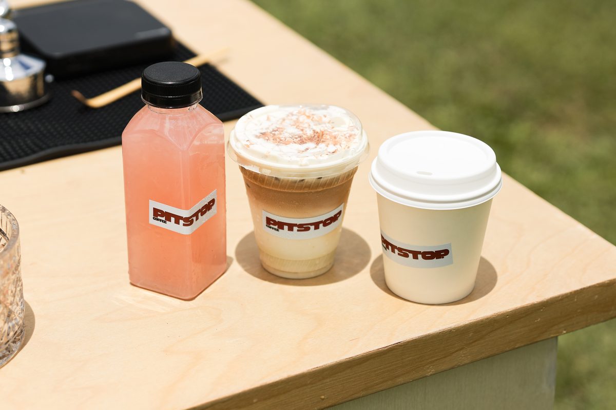 A bottled refresher and two coffees lined up on the counter